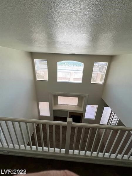 stairway featuring a textured ceiling