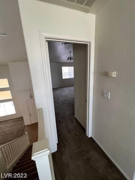 hallway with dark colored carpet