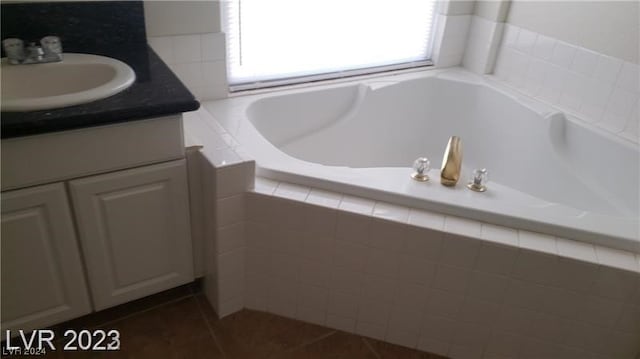 bathroom featuring vanity, tile floors, and tiled bath