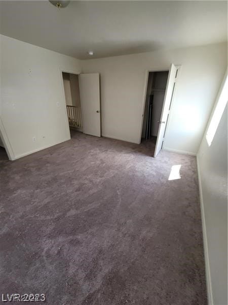 unfurnished bedroom with dark carpet