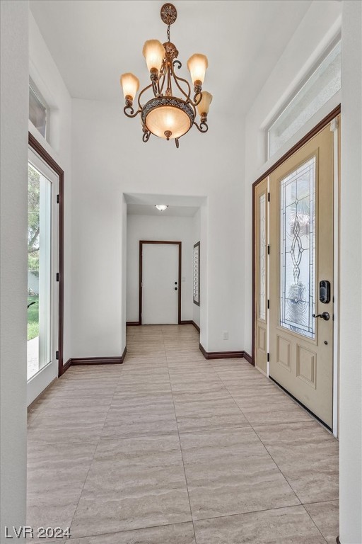 foyer with an inviting chandelier and light tile floors