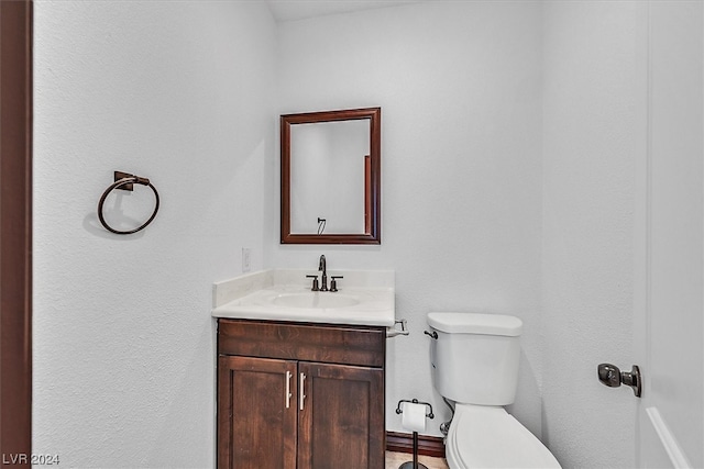 bathroom featuring toilet and vanity with extensive cabinet space