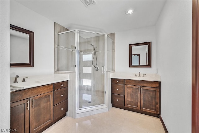 bathroom with a shower with door, tile flooring, and vanity