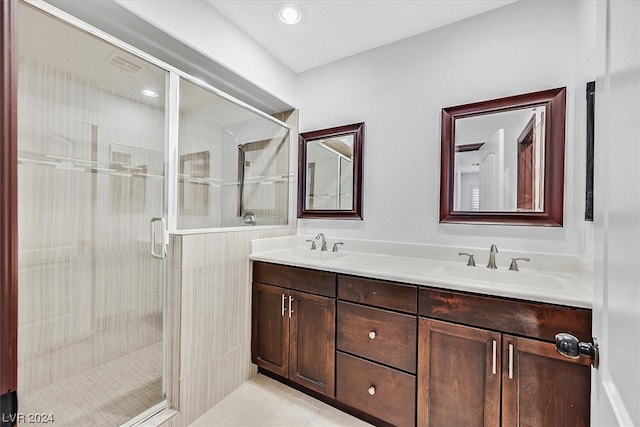 bathroom with double sink vanity and a shower with door