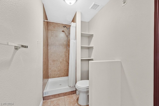 bathroom with toilet, tile floors, and a shower with shower curtain