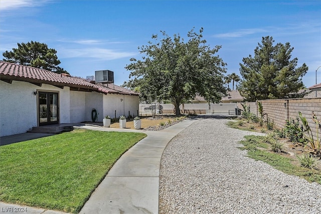 view of yard featuring central air condition unit and french doors