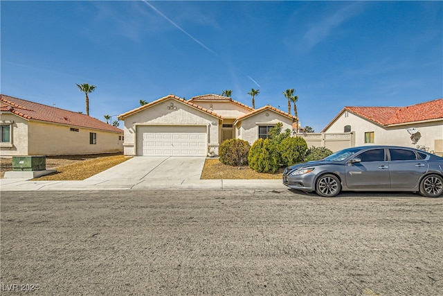5717 Wizard Wand St, North Las Vegas, NV 89031 - mediterranean / spanish house featuring driveway, a tiled roof, an attached garage, and stucco siding