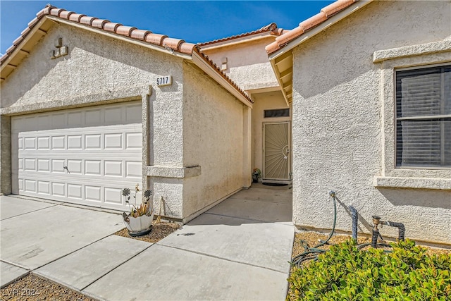 5717 Wizard Wand St, North Las Vegas, NV 89031 - entrance to property with stucco siding, a garage, and a tile roof