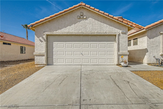 5717 Wizard Wand St, North Las Vegas, NV 89031 - mediterranean / spanish home with concrete driveway, a garage, stucco siding, and a tiled roof