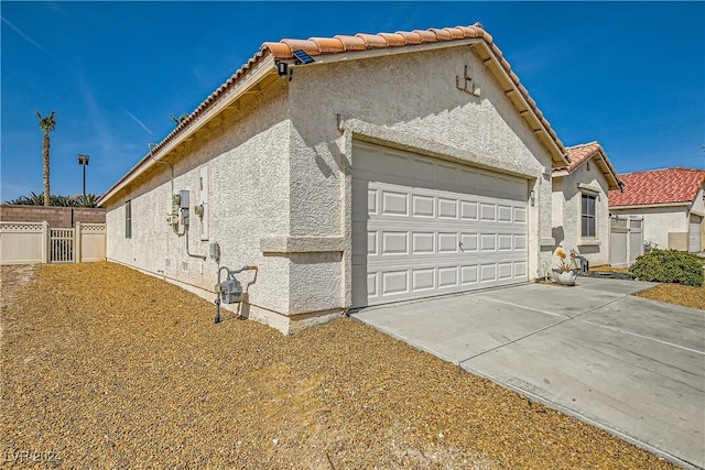 5717 Wizard Wand St, North Las Vegas, NV 89031 - view of home's exterior featuring stucco siding, a garage, concrete driveway, and a tile roof