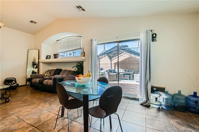 tiled dining space with vaulted ceiling