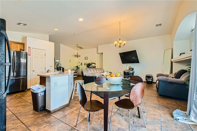5717 Wizard Wand St, North Las Vegas, NV 89031 - tiled dining room featuring a chandelier, vaulted ceiling, and a sink