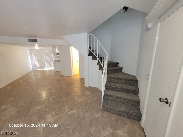 staircase with a textured ceiling