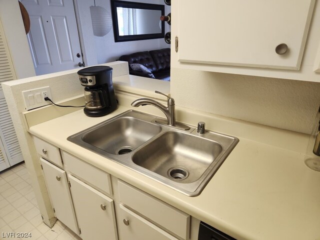 kitchen with white cabinets, light tile floors, and sink