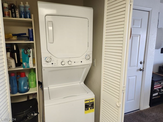 washroom featuring stacked washer and clothes dryer and dark colored carpet