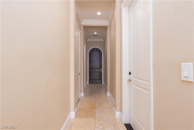 hallway featuring light tile flooring and crown molding