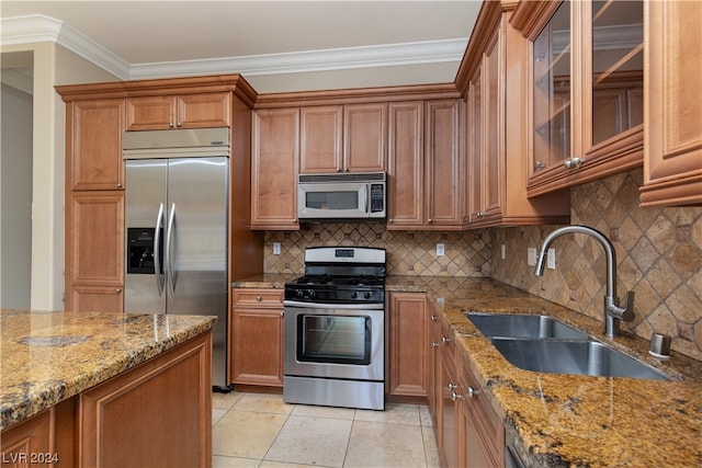 kitchen featuring light stone countertops, appliances with stainless steel finishes, sink, light tile floors, and tasteful backsplash