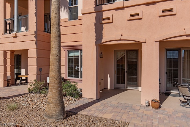 property entrance with a balcony and a patio