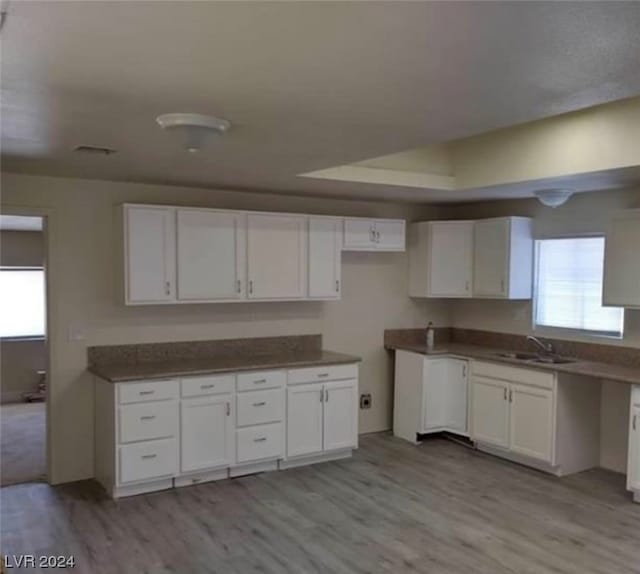 kitchen featuring white cabinets, sink, and light hardwood / wood-style floors