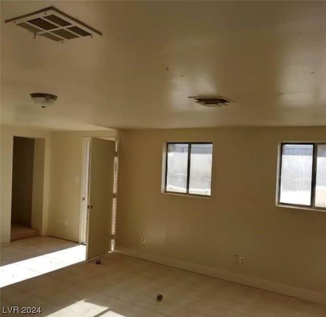 tiled empty room featuring a healthy amount of sunlight