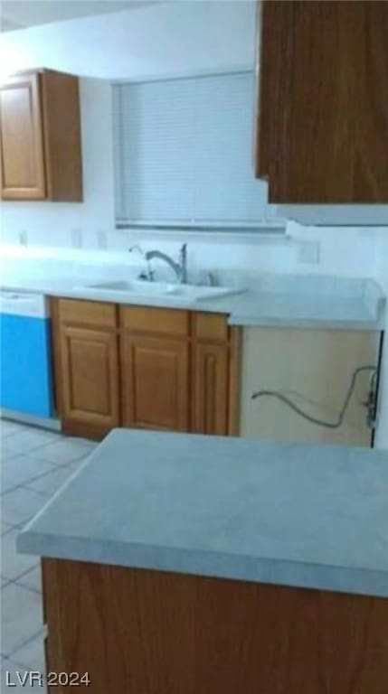 kitchen with dishwasher, sink, and light tile floors