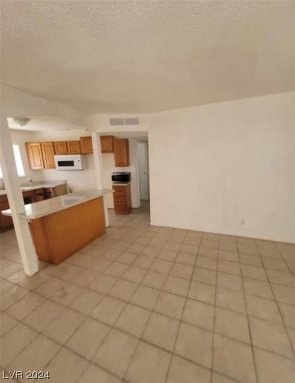 kitchen featuring light tile floors and a textured ceiling