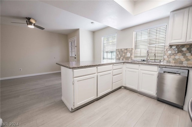 kitchen with sink, white cabinetry, stainless steel dishwasher, and tasteful backsplash