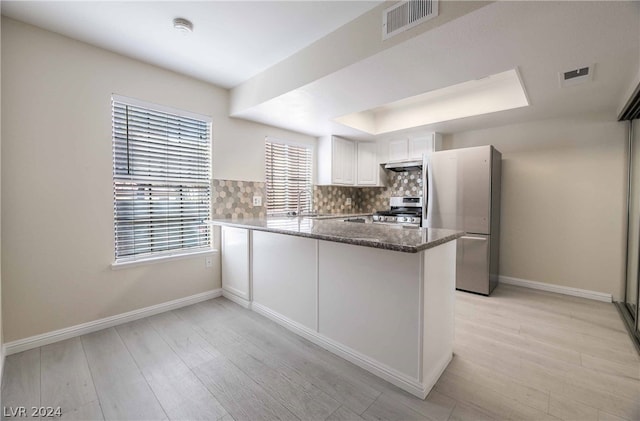 kitchen featuring white cabinetry, sink, light hardwood / wood-style flooring, stainless steel appliances, and tasteful backsplash