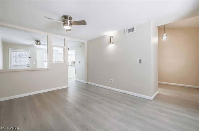 unfurnished room with ceiling fan and light wood-type flooring