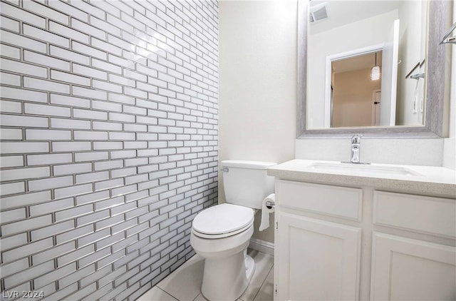 bathroom with tile flooring, oversized vanity, toilet, and tile walls