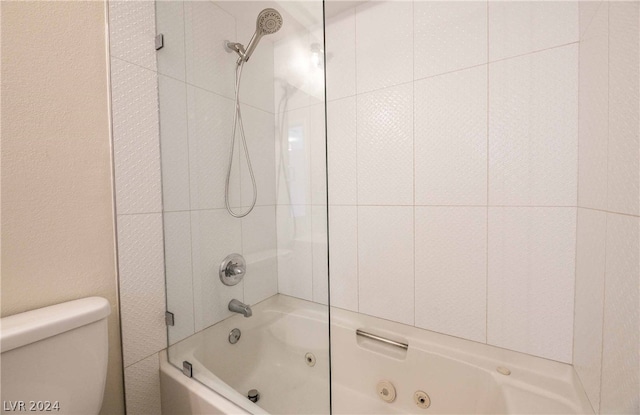 bathroom with toilet and tiled shower / bath