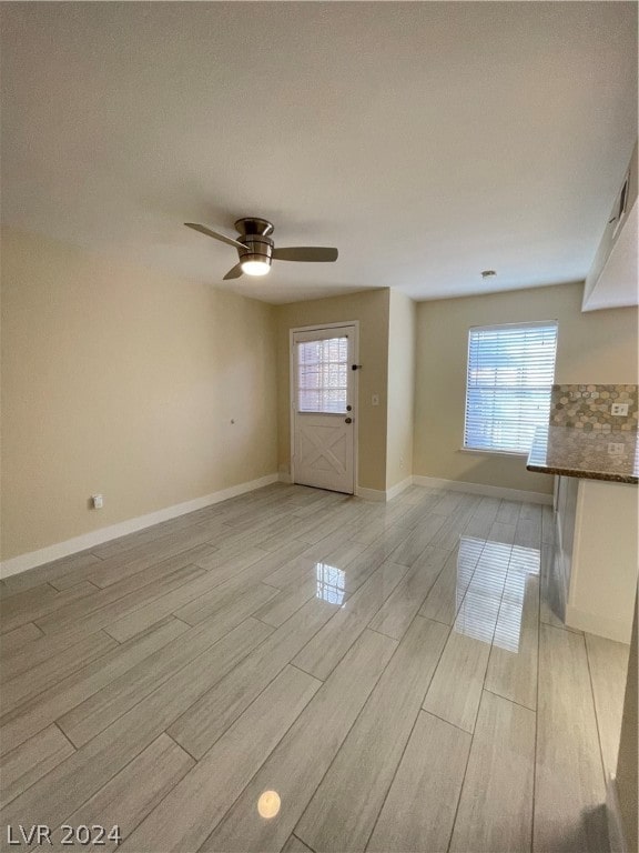 unfurnished room featuring ceiling fan, light wood-type flooring, and plenty of natural light