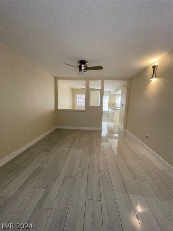 empty room with light hardwood / wood-style floors and ceiling fan