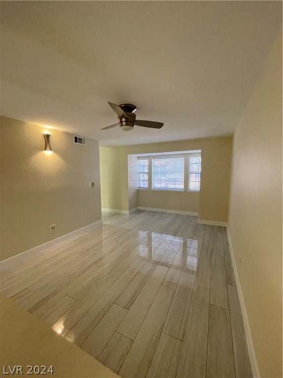 empty room featuring ceiling fan and light wood-type flooring