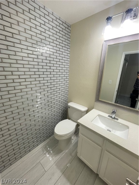 bathroom featuring tile floors, toilet, and vanity