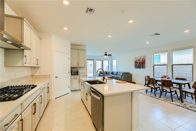 kitchen with a kitchen island with sink, sink, wall chimney exhaust hood, ceiling fan, and appliances with stainless steel finishes