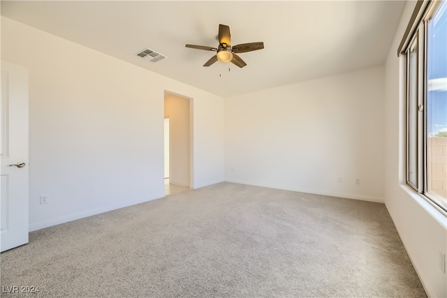 spare room featuring ceiling fan and light colored carpet