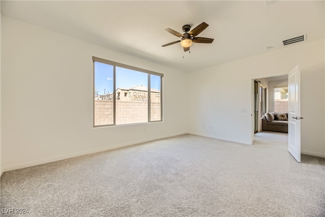 spare room featuring light carpet and ceiling fan