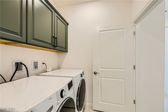 washroom with cabinets, sink, and washing machine and clothes dryer