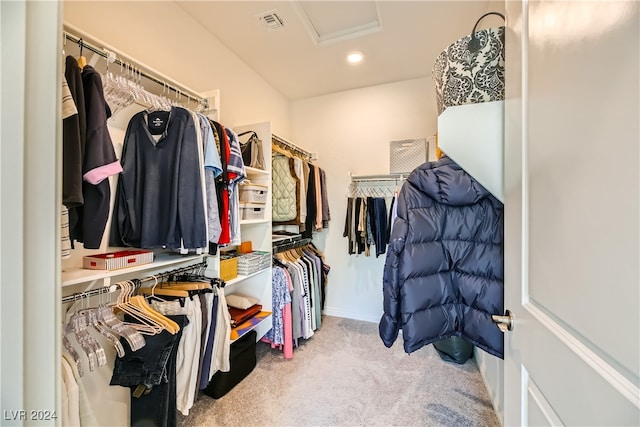 walk in closet featuring light carpet