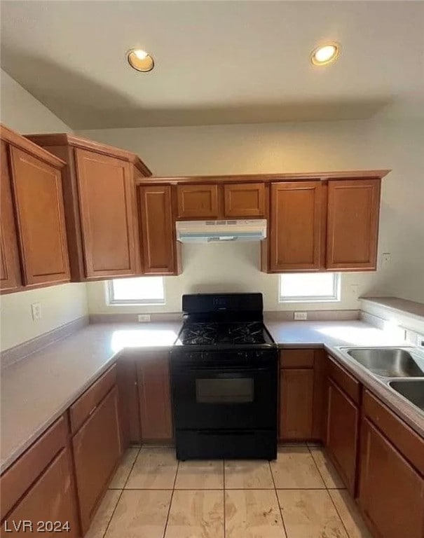 kitchen featuring black gas range oven and light tile flooring