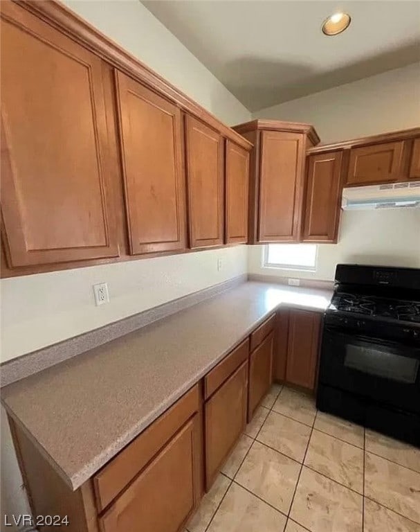 kitchen with light tile flooring and black gas stove