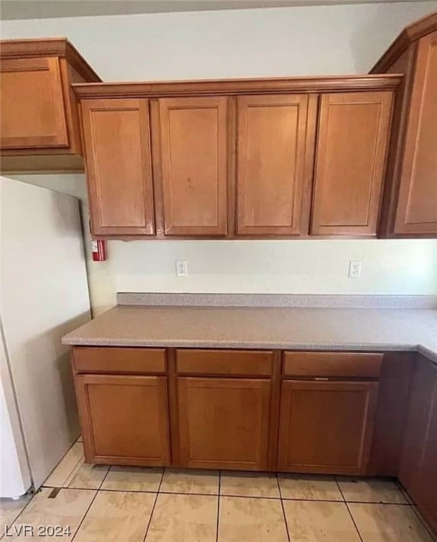 kitchen with stainless steel fridge and light tile floors