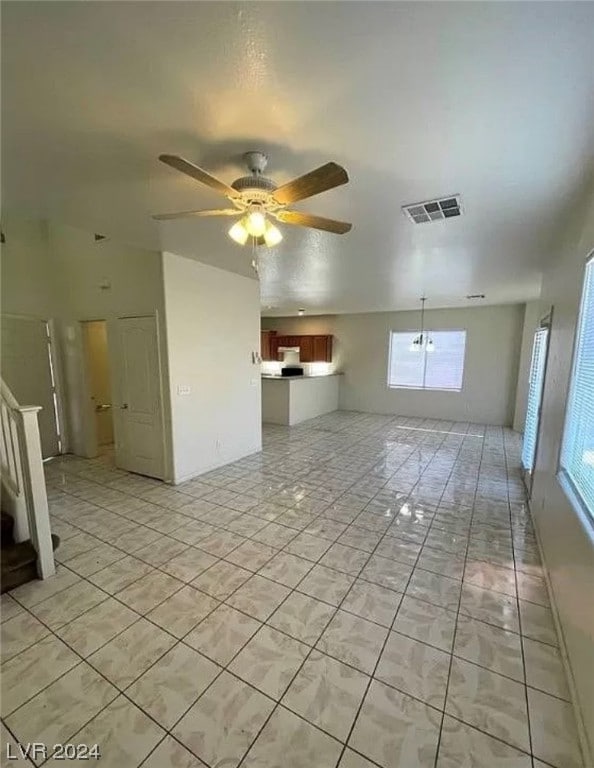 tiled spare room featuring plenty of natural light and ceiling fan