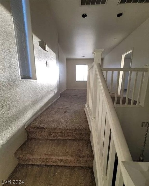 stairway with dark carpet and ornate columns