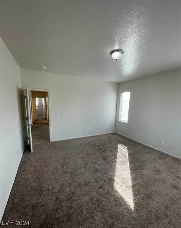 carpeted empty room featuring a textured ceiling