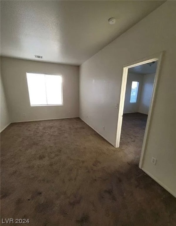 carpeted empty room with a textured ceiling