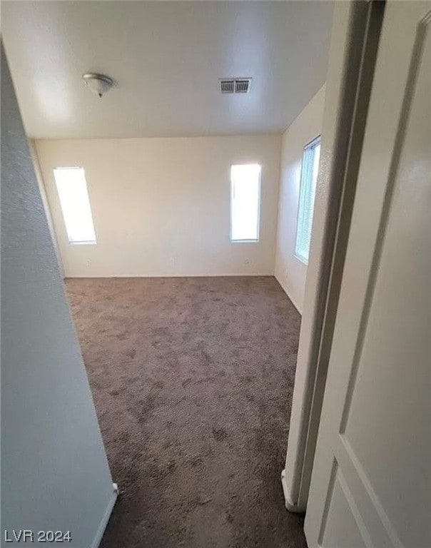 spare room with dark carpet