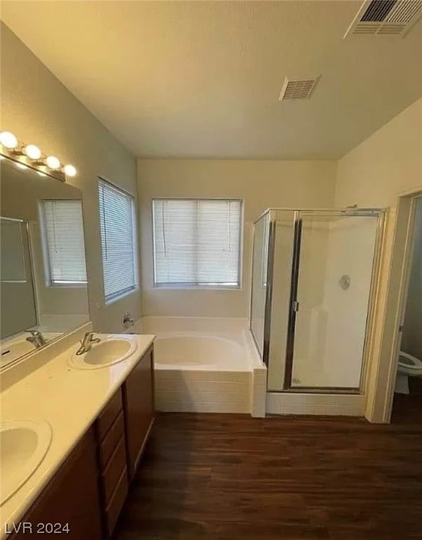 full bathroom featuring plus walk in shower, toilet, hardwood / wood-style flooring, and dual bowl vanity