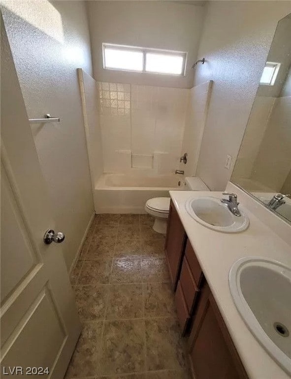 full bathroom featuring tile floors, double sink vanity, toilet, and tiled shower / bath